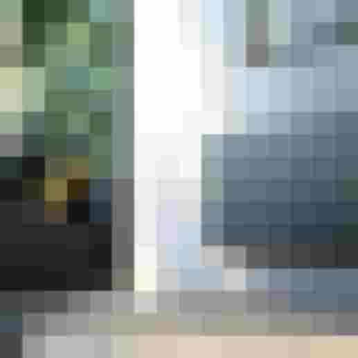 Moderner schwarzer Heizkörper neben grauem Sofa mit gelben Kissen