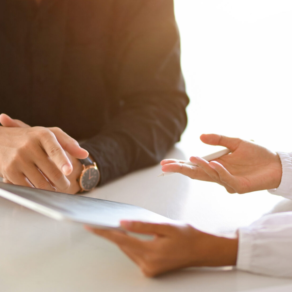 Zwei Personen besprechen etwas mit Tablet am Tisch